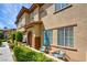 Charming two-story townhome showcasing manicured landscaping, a cozy patio, and beautiful architectural details at 3840 Belle Glade St # 104, Las Vegas, NV 89129