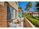 Relaxing patio with comfortable seating, an umbrella, and views of lush landscaping and palm trees at 3840 Belle Glade St # 104, Las Vegas, NV 89129