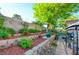 Backyard with retaining walls and lush landscaping featuring a green egg grill and covered dining area at 4517 Inez Dr, Las Vegas, NV 89130