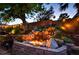 Backyard oasis featuring a stone waterfall feature, fire pit, and lush greenery at 4517 Inez Dr, Las Vegas, NV 89130