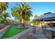Backyard featuring a patio area, dining set, and lush landscaping with mature palm trees at 4517 Inez Dr, Las Vegas, NV 89130