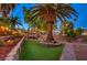 Beautifully landscaped backyard with a swing set, mature palm trees, and green artificial turf at 4517 Inez Dr, Las Vegas, NV 89130