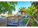 Serene backyard with a fire pit, swing set, mature palms, and landscaped areas at 4517 Inez Dr, Las Vegas, NV 89130