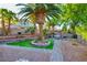 Lush backyard with a swing set, fire pit, mature palms, and attractive landscaping at 4517 Inez Dr, Las Vegas, NV 89130