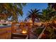 Backyard lounge area with a fire pit, wooden pergola swing set, and garden beds at 4517 Inez Dr, Las Vegas, NV 89130