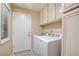 Laundry room with white washer and dryer, cabinets, and access door at 4517 Inez Dr, Las Vegas, NV 89130