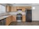 Functional kitchen with wood cabinetry, modern stainless steel appliances, and ample counter space at 5135 Paradise Valley Ave, Las Vegas, NV 89156