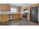 Well-lit kitchen with wood cabinets, modern appliances including a stainless steel dishwasher at 5135 Paradise Valley Ave, Las Vegas, NV 89156