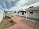 Spacious backyard with brick pavers, covered patio, and white concrete block fencing at 5324 Holmby Ave, Las Vegas, NV 89146
