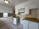 Eat-in kitchen with white cabinets, wood countertops, tile flooring and microwave at 5324 Holmby Ave, Las Vegas, NV 89146