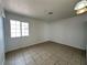 Living room featuring tile flooring, a large window for natural light, and neutral wall paint at 5324 Holmby Ave, Las Vegas, NV 89146