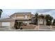 Stately two-story brick home featuring a tile roof, front-facing garage, and desert landscaping at 5770 El Camino Rd, Las Vegas, NV 89118