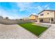 Expansive backyard with artificial turf, gravel landscaping, and a covered patio offers low-maintenance outdoor living at 6405 Strongbow Dr, Las Vegas, NV 89156
