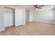 Bright bedroom features a ceiling fan, closet with folding doors, and sleek, light-colored flooring at 6405 Strongbow Dr, Las Vegas, NV 89156