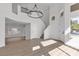 Bright living room with high ceilings, modern chandelier, wood-style flooring and multiple windows at 6509 Old Oxford Ave, Las Vegas, NV 89108