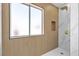Walk-in shower featuring wood-look tile, marble accents, and a built-in niche at 6509 Old Oxford Ave, Las Vegas, NV 89108