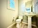 Half bathroom with tile flooring, a pedestal sink, and a toilet at 6639 Ivory Dove Ct, Las Vegas, NV 89148