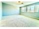 Bright, carpeted bedroom with two large windows and neutral walls at 6639 Ivory Dove Ct, Las Vegas, NV 89148