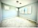 Clean and bright bedroom with a window, neutral carpet, and light blue walls at 6639 Ivory Dove Ct, Las Vegas, NV 89148