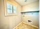 Compact laundry room featuring tiled floors, storage shelf, and access to utilities at 6639 Ivory Dove Ct, Las Vegas, NV 89148
