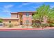A two-story building exterior with a tile roof, tan stucco, and desert landscaping at 6868 Sky Pointe Dr # 2013, Las Vegas, NV 89131