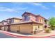 Exterior of a two-story townhome with a two-car garage, desert landscaping, and a tile roof at 6868 Sky Pointe Dr # 2013, Las Vegas, NV 89131