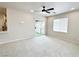 Bright living space with carpet flooring, ceiling fan, and sliding glass door to an outdoor space at 6868 Sky Pointe Dr # 2013, Las Vegas, NV 89131