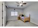 Cozy bedroom featuring plush carpet, a ceiling fan, and natural light from the window at 7256 Bugler Swan Way, North Las Vegas, NV 89084