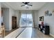 Bright living room with wood floors, ceiling fan, and sliding glass doors to the pool area at 7256 Bugler Swan Way, North Las Vegas, NV 89084