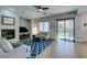 Cozy living room features a fireplace, blue patterned rug, and sliding glass doors to backyard at 7256 Bugler Swan Way, North Las Vegas, NV 89084
