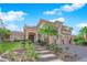 Elegant home showcasing a beautiful stone entrance and lush, landscaped surroundings at 807 Canyon Greens Dr, Las Vegas, NV 89144