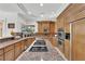 Gourmet kitchen showcases granite counters, custom wood cabinets, and a cooktop island at 807 Canyon Greens Dr, Las Vegas, NV 89144