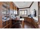 Well-lit home office with custom wood paneling, built-ins, and large windows at 807 Canyon Greens Dr, Las Vegas, NV 89144
