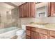 Bathroom featuring granite counters, wood cabinets, tub and stand-up shower at 9000 Las Vegas Blvd # 2243, Las Vegas, NV 89123
