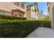 Enclosed backyard patio with hedge and view of neighboring homes at 9228 Whitekirk Pl, Las Vegas, NV 89145