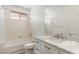 Bathroom with a combined shower and bath, modern marbled vanity, and white walls at 9228 Whitekirk Pl, Las Vegas, NV 89145