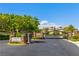 Elegant gated entrance to Tudor Park at Queensridge, featuring stone pillars and lush landscaping under a clear blue sky at 9228 Whitekirk Pl, Las Vegas, NV 89145