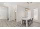 Bright dining room features modern chandelier lighting, a table with seating, and wood-look flooring at 9228 Whitekirk Pl, Las Vegas, NV 89145