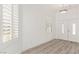 Welcoming entryway with wood-look floors, white walls, plantation shutters, and a double front door at 9228 Whitekirk Pl, Las Vegas, NV 89145