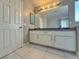 Bright bathroom featuring white cabinets, a large mirror, and tiled floors at 9509 Arrowhead Falls Ct, Las Vegas, NV 89148