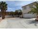 A wide driveway leads to the garage of this two-story residence featuring mature palm trees at 9509 Arrowhead Falls Ct, Las Vegas, NV 89148