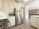Bright kitchen features white cabinets and stainless steel refrigerator and appliances at 9509 Arrowhead Falls Ct, Las Vegas, NV 89148