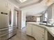 Spacious kitchen featuring white cabinets, stainless steel appliances, and updated sink with views to living room at 9509 Arrowhead Falls Ct, Las Vegas, NV 89148