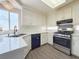 Modern kitchen featuring white cabinets, stainless steel appliances, and updated countertops and flooring at 9509 Arrowhead Falls Ct, Las Vegas, NV 89148
