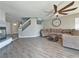 Bright living room with fireplace, ceiling fan, staircase with glass panels and wood-look floors at 9509 Arrowhead Falls Ct, Las Vegas, NV 89148