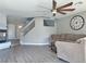 Bright living room with fireplace, ceiling fan, staircase with glass panels and wood-look floors at 9509 Arrowhead Falls Ct, Las Vegas, NV 89148