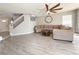 Open living room with modern ceiling fan, neutral paint, and staircase with glass panels at 9509 Arrowhead Falls Ct, Las Vegas, NV 89148