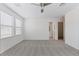 Bright bedroom with neutral carpet, ceiling fan, and ensuite bathroom and walk-in closet access at 10943 Ketchikan St, Las Vegas, NV 89179