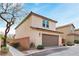 Two-story home with attached garage, featuring desert landscaping and a brick surround at 10943 Ketchikan St, Las Vegas, NV 89179
