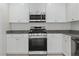 Well-equipped kitchen featuring white cabinets, granite countertops, and stainless steel appliances at 10943 Ketchikan St, Las Vegas, NV 89179